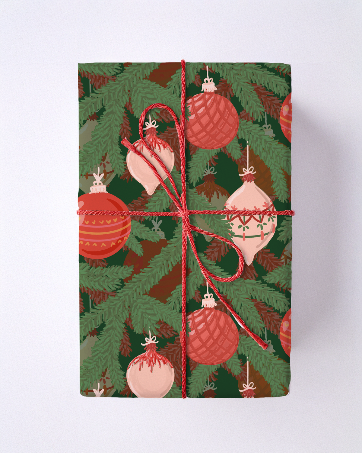 Christmas wrapping paper with red ornaments and green pine branches