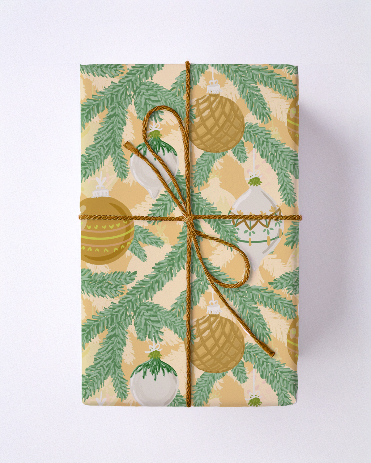 Yellow and green wrapping paper with pine branches and ornaments.
