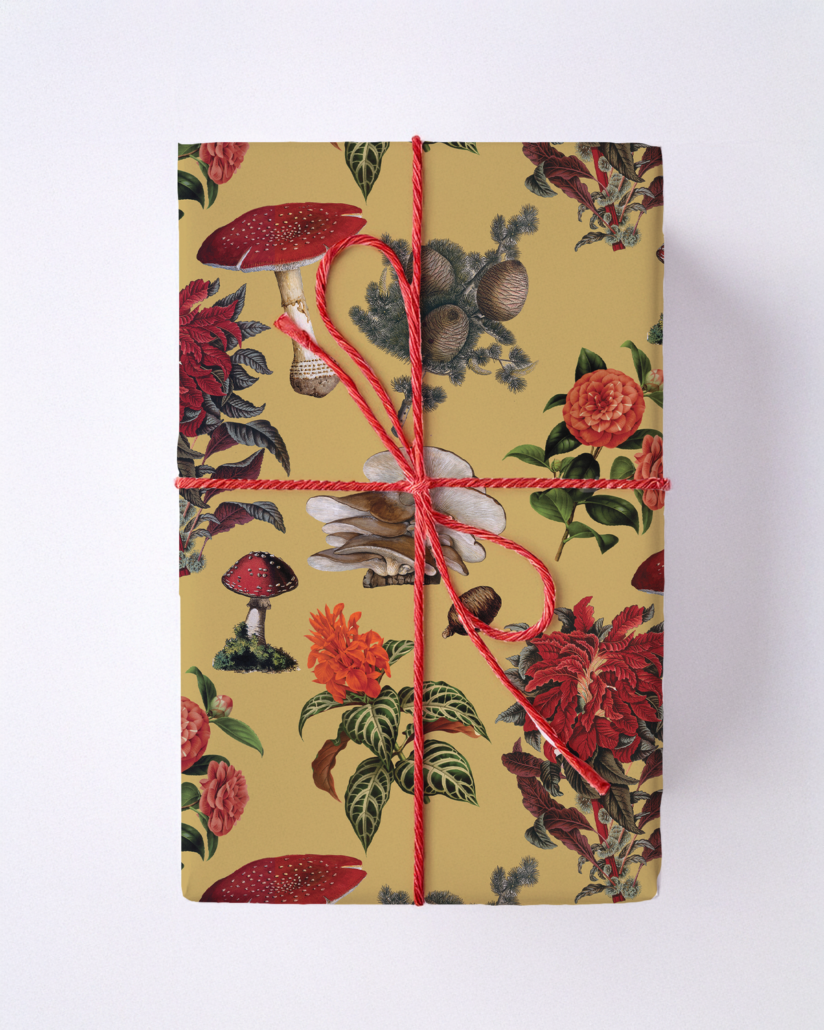 Yellow wrapping paper with red mushrooms and floral motifs tied with red string.